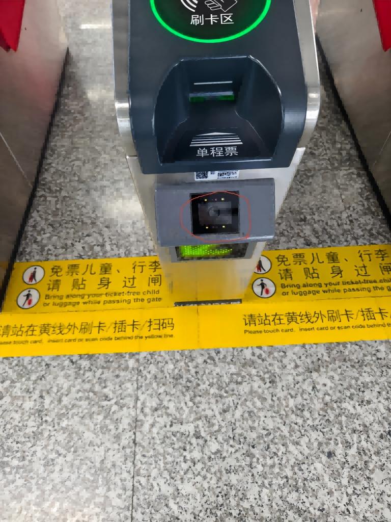 Phone held up to metro gate QR scanner camera